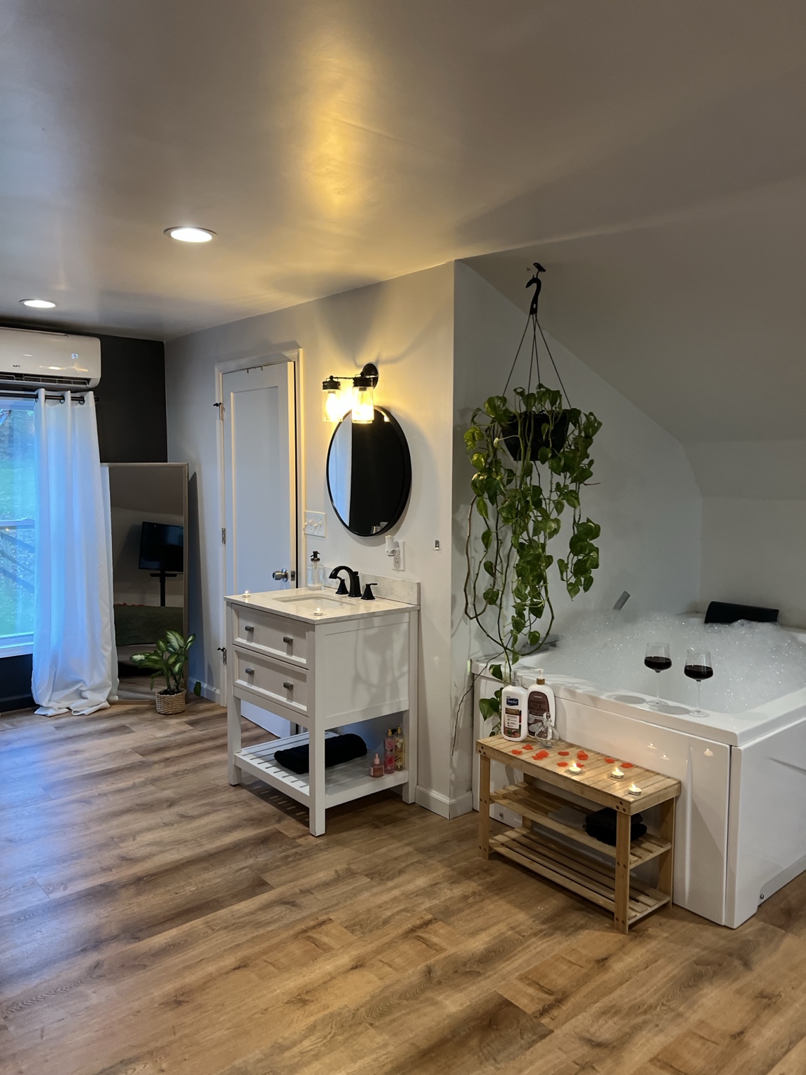Vanity and candlelit tub with the mirror reflecting the loft