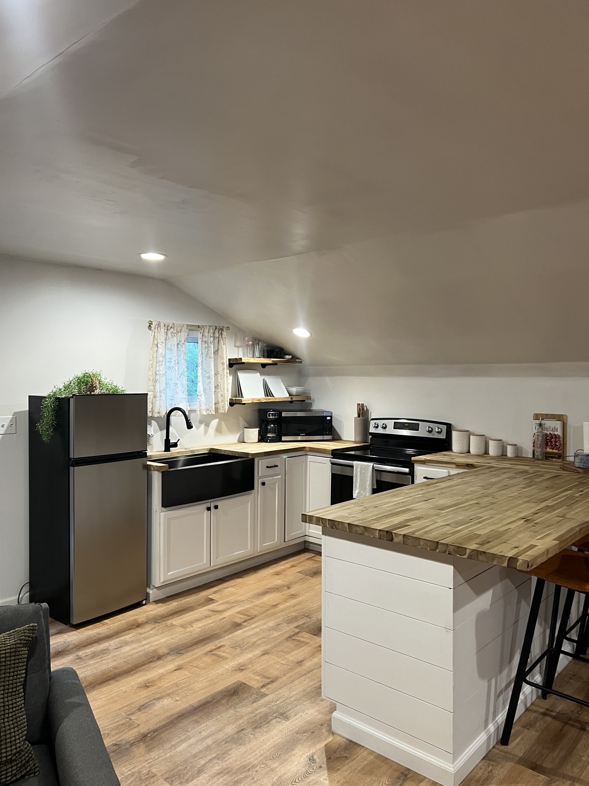 Kitchen with farmhouse sink, full range, microwave and coffee maker