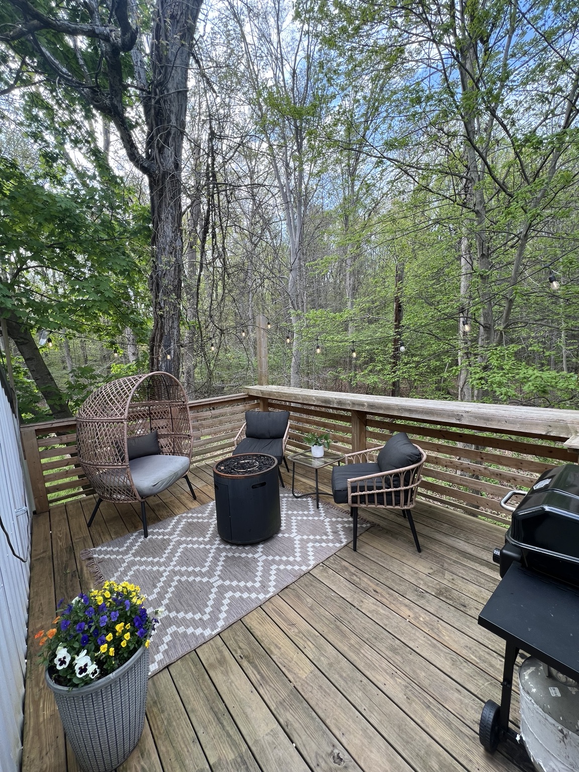 Fire table and rattan seating on the deck under the canopy