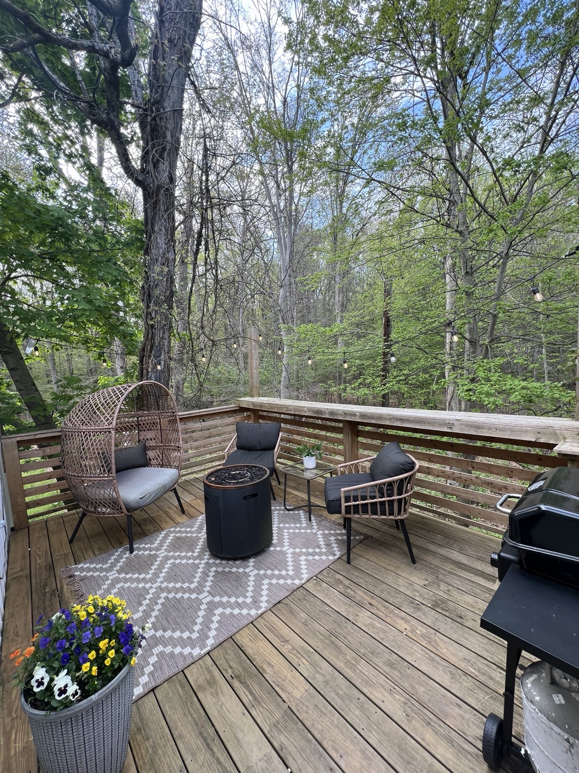 Deck lounge seating surrounded by spring woodland