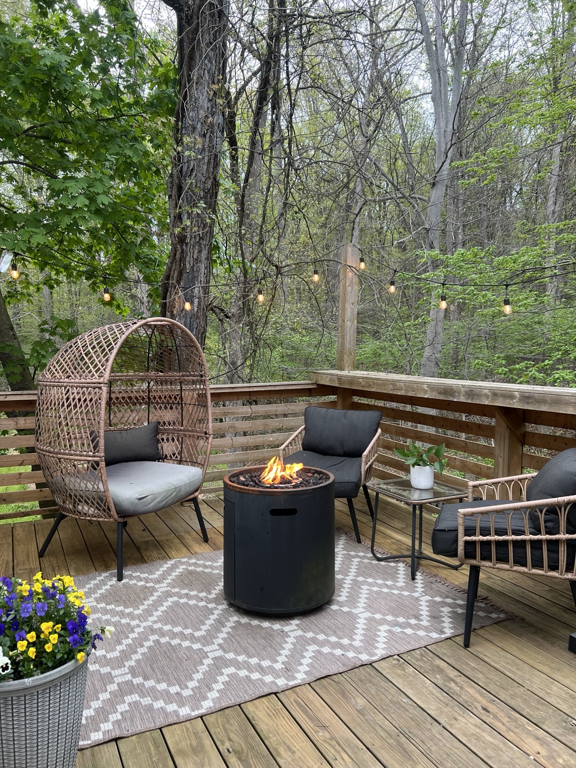 Fire pit glowing on the private deck under string lights