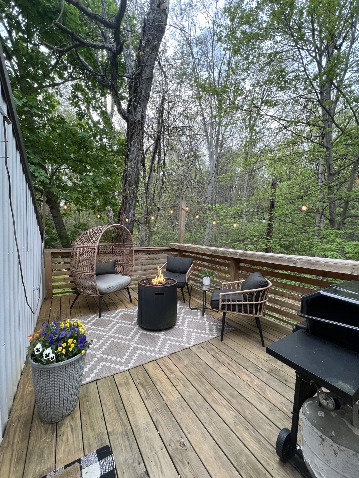 Deck seating with egg chair, grill and woodland views
